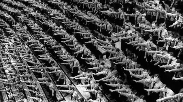 An Associated Press photograph shows some of over 132,000 members of the Hitler youth organisation assembled at the Olympic Stadium in Berlin, where German Chancellor Adolf Hitler and Dr. Joseph Goebbels addressed them, as part of the usual round of May Day festivities and demonstrations in Germany on May 1, 1939. The AP caption notes: 'The Fuhrer arrives and the members of the Hitler youth organisation rise as one man to give the Nazi salute at the demonstration in the Olympic Stadium, Berlin.'