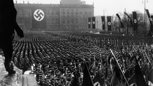 The Associated Press photographs the third anniversary of National Socialism's accession to power in 1933 widely celebrated throughout Germany on Feb. 11, 1936. At noon, Adolf Hitler assembled 25,000 of his oldest stormtroop comrades in the Lustgarten in Berlin. In his address, Hitler reiterated Germany’s will to peace. This is a general view of the banner and flag bearers in Berlin.