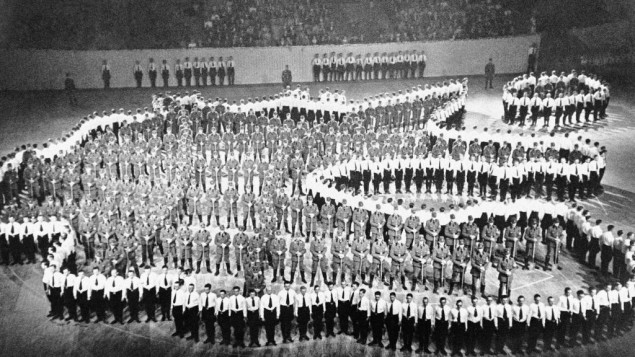 An Associated Press photograph shows what it calls men 'making up this human map of greater Germany. They are members of Labor Service Corps at the International Handicraft Congress in Berlin, May 28, 1938. Those in white shirts represent the boundaries; those inside, in brown shirts, with spades, are intended to represent Germany's network of auto roads. Note that the absorption of Austria is recognized. Note also the little island at the upper right representing East Prussia, and the deep dent at the right center where Czechoslovakia sticks its long neck into Germany.'