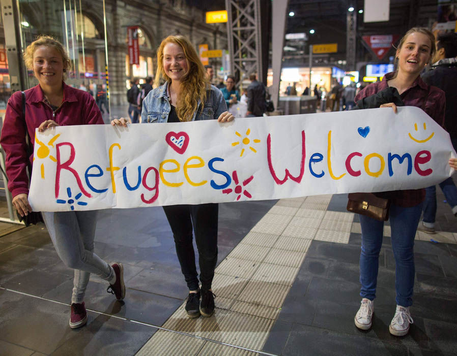 women_refugees_welcome_sign